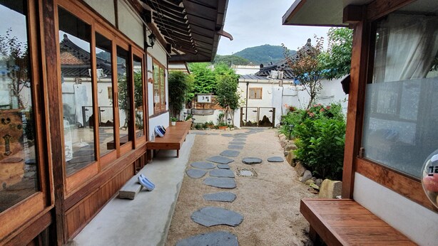 A traditional Japanese-style building with wooden sliding doors and a stone pathway leading to a wooden bench. - Jeonju Greem (Jeonju)