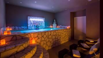 A spa area with a stone wall, a Buddha statue, and a pool.