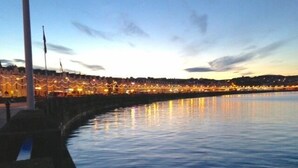A waterfront promenade with a calm river reflecting lights from the buildings. - Bed and Blueberry, Two Bedroom Suite (Douglas)