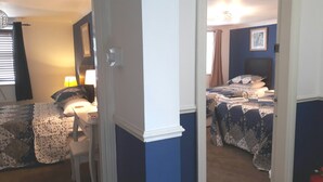 A bedroom with two beds, a bedside table with a lamp, and a chair. - Bed and Blueberry, Two Bedroom Suite (Douglas)