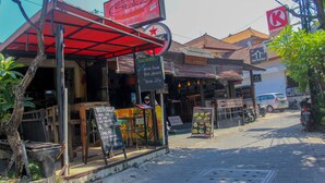 A street view with a restaurant named 'StakZ' and a 'Tat Too Hut' across the street. - Bali Manik Beach Inn (Kuta)