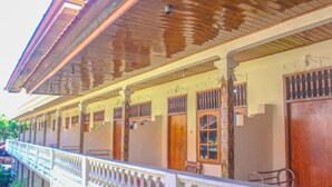 A traditional building with a balcony, wooden doors, and a tiled roof. - Bali Manik Beach Inn (Kuta)