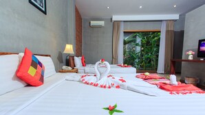 A hotel room with a neatly made bed, a bedside table with a lamp, a TV, and a window with curtains. - Saravoan Royal Palace (Phnom Penh)