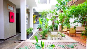 A modern indoor garden with a small pond, potted plants, and a seating area. - Saravoan Royal Palace (Phnom Penh)