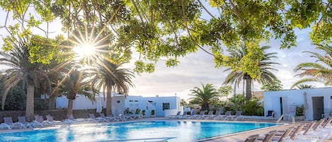 Piscine couverte, piscine extérieure, parasols de plage, chaises longues