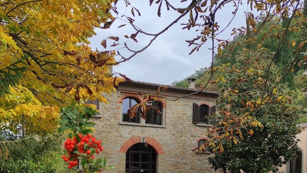 A stone building with arched windows and a gravel driveway.