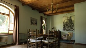 A dining area with a wooden table and chairs, a chandelier, and artwork on the walls.