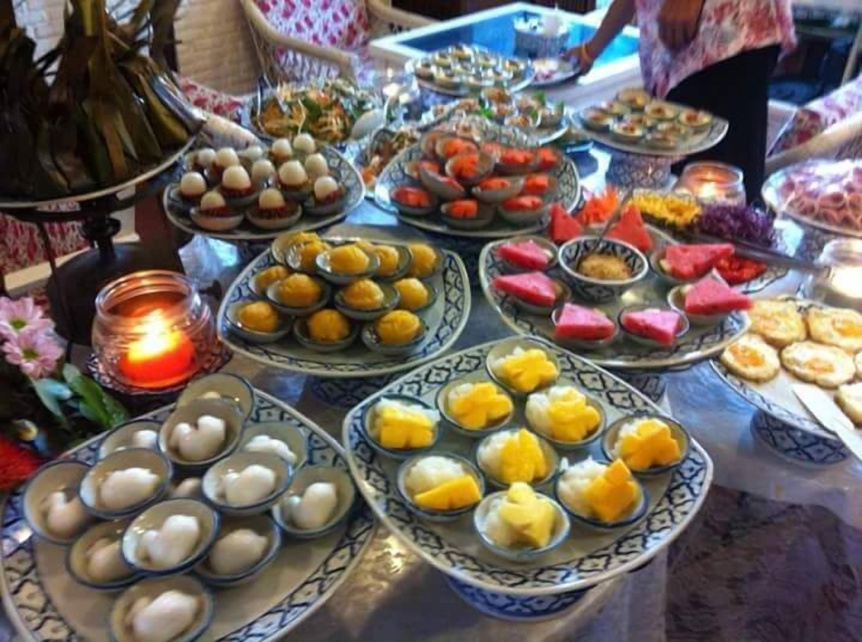 A table with various dishes, including bowls of food and a lit candle.