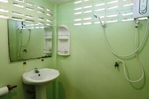 Un baño con lavamanos, espejo y ducha.