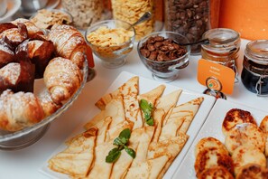 A breakfast buffet with pastries, cereals, and condiments. - Orange Hotel (Odesa)