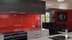 A modern kitchen with a gas stove, a built-in oven, and a white countertop. - Lakeview Holiday Home (Rotorua)