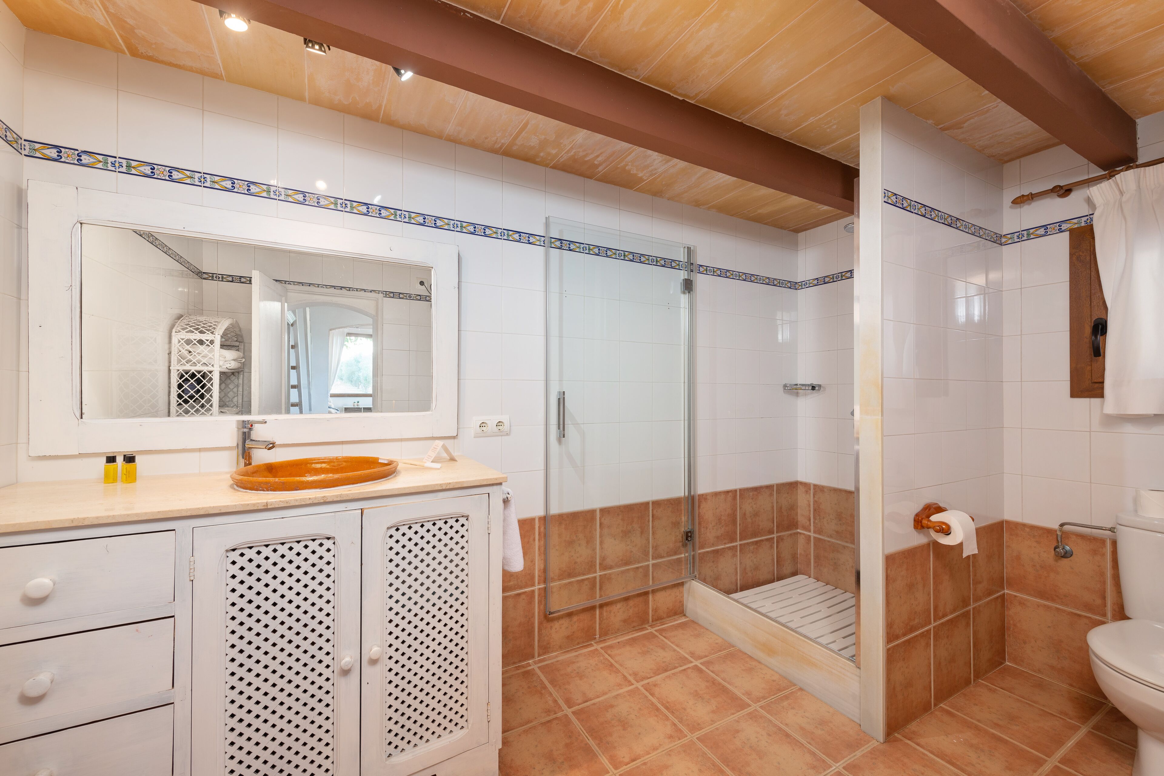 Ein Badezimmer mit Waschbecken, Spiegel, Dusche und Toilette.