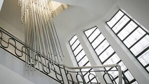 A staircase with a metal railing and large windows. - Villa Fani (Thiers)