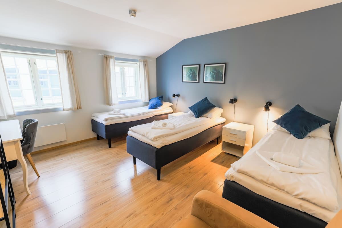 Ein Hotelzimmer mit zwei Betten, einem Schreibtisch und einem Stuhl.