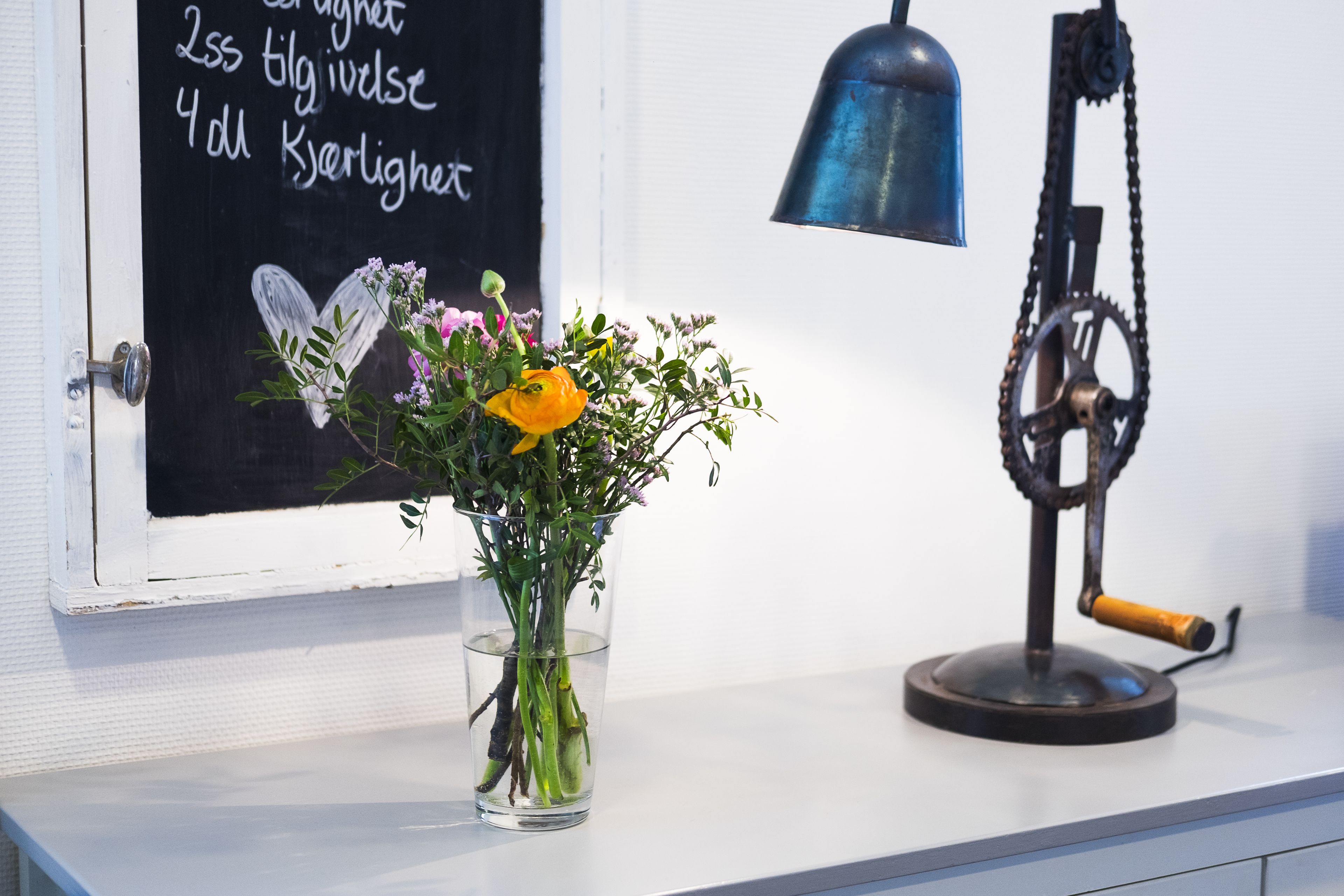 A window with a chalkboard displaying text and a mechanical device on a counter.