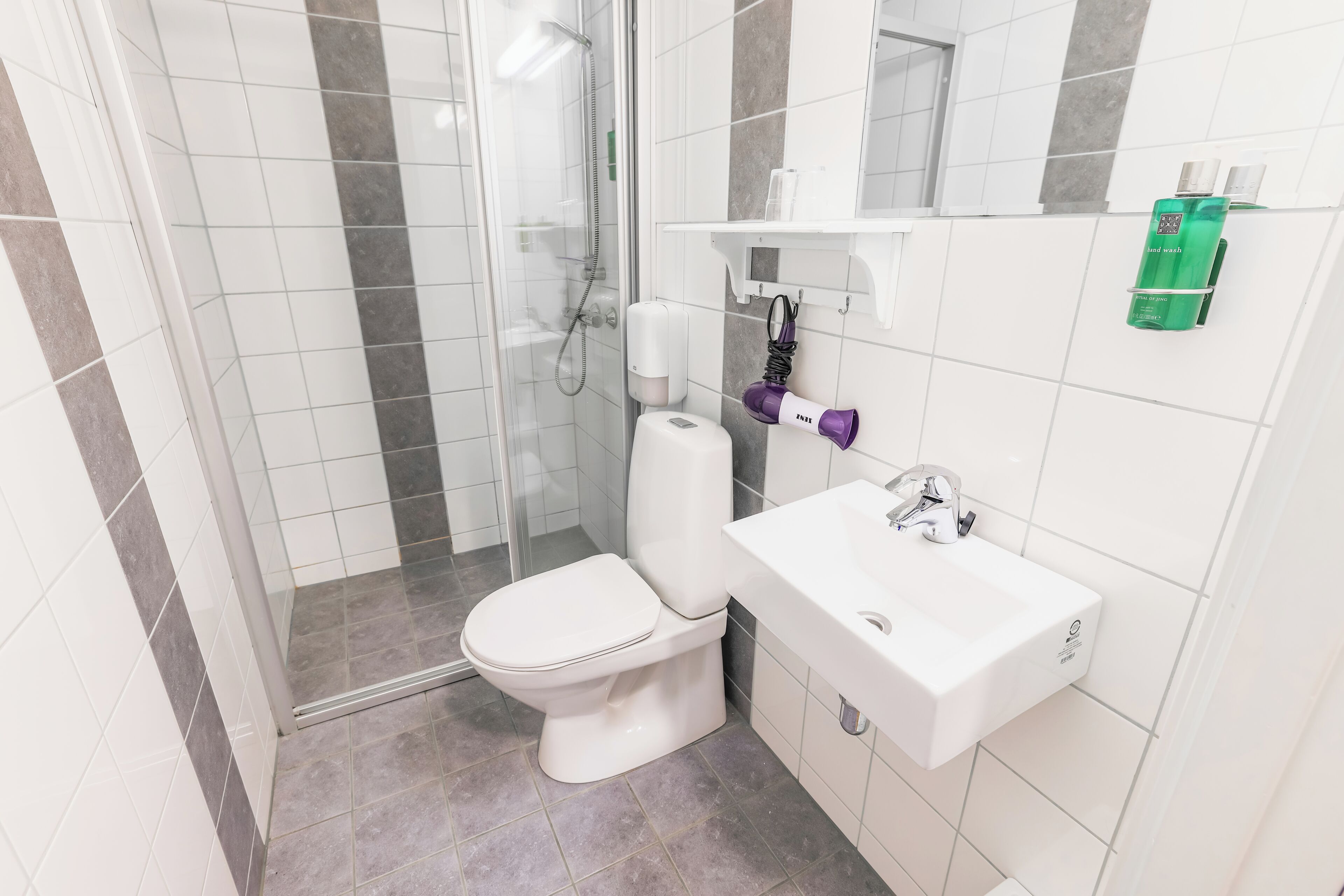 Un baño con inodoro, lavabo y ducha.