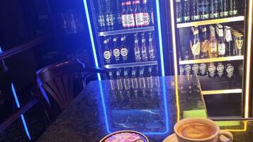 A bar area with shelves of bottled beverages, a coffee cup, and a Guinness coaster.