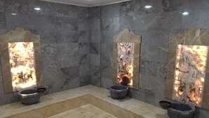 Un baño con tres lavamanos, cada uno con un espejo decorativo y un lavabo.