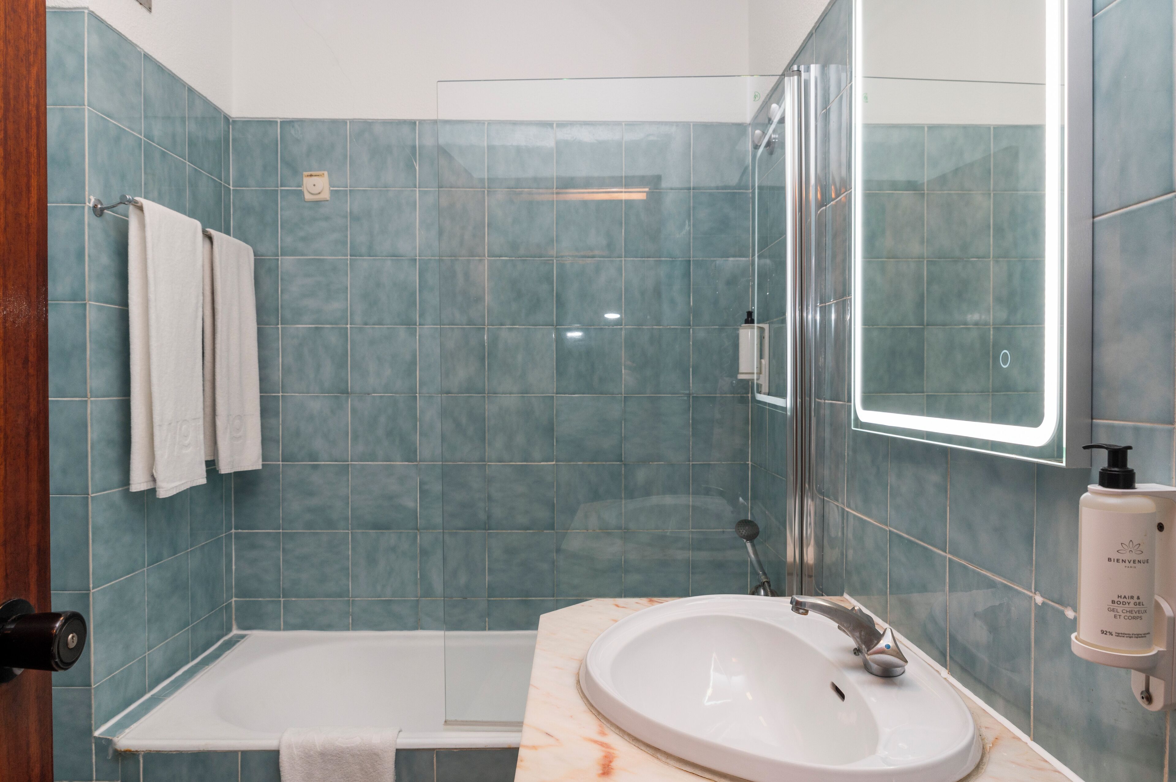 Un baño con bañera, lavamanos y cabina de ducha de vidrio.