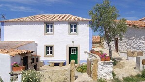 A traditional white building with a green door, a tiled roof, and stone walls. - Aldeia da Mata Pequena (Mafra)