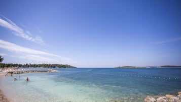 NĂ€ra stranden, vit sandstrand, solstolar och parasoller