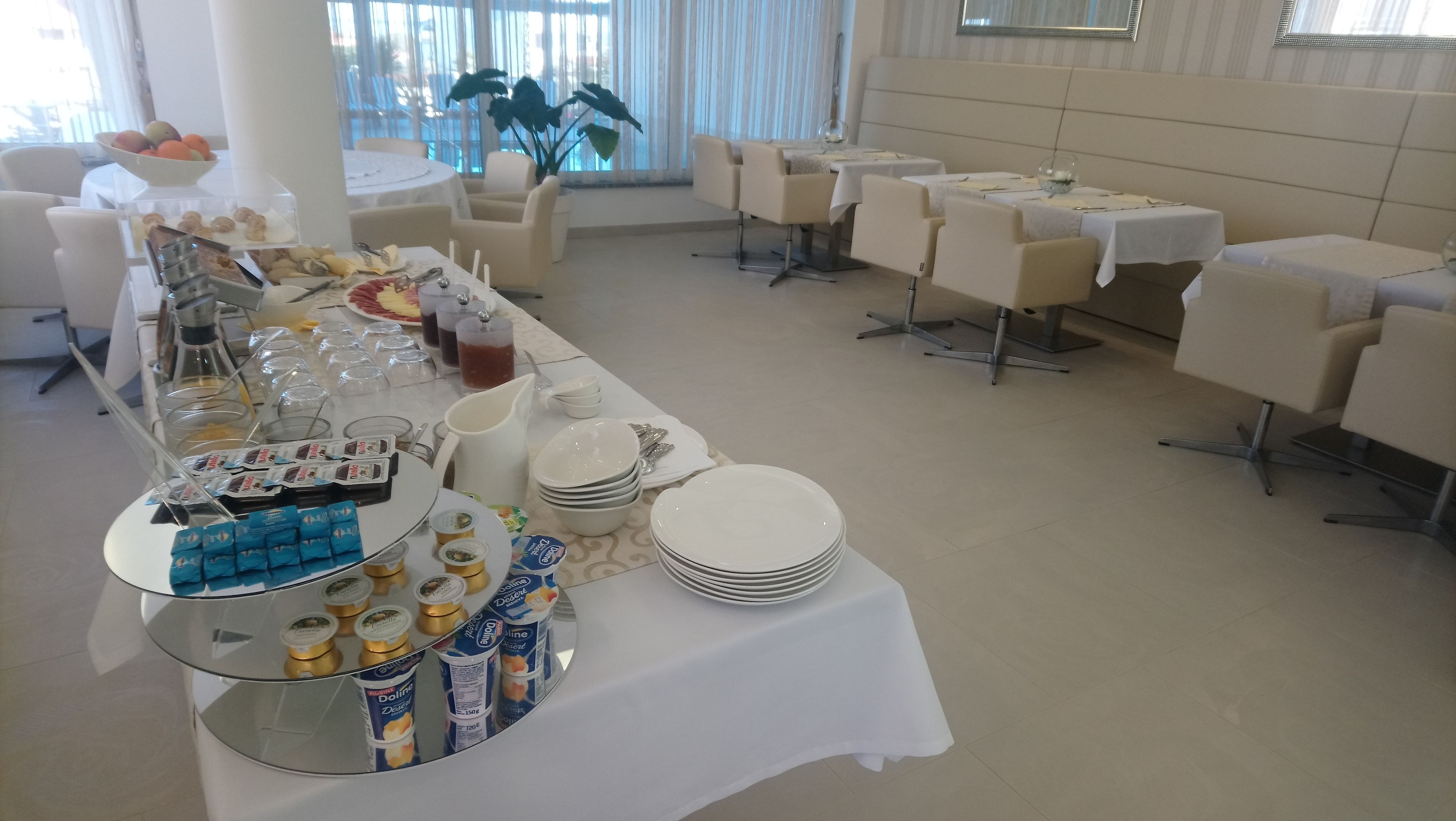 Un buffet proposant une variété d'aliments et de boissons, notamment des yaourts, des fruits et un assortiment de boissons.