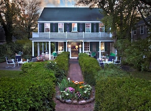 A two-story building with a covered porch and outdoor seating area.