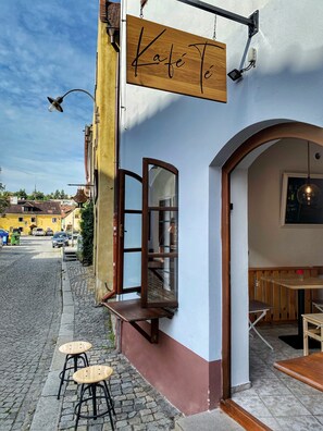 A cafe named "Cafe Tê" with outdoor seating and a visible window. - Penzion Weber (Cesky Krumlov)