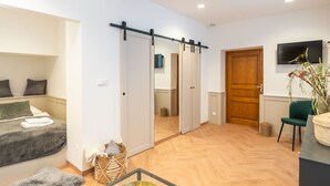 Una habitación moderna con cama, escritorio, silla, televisor y armario corredero.