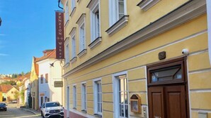 Un edificio amarillo con una puerta de madera grande y un letrero encima.
