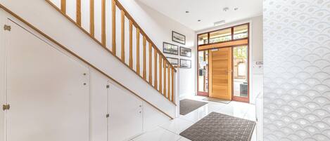 A staircase with wooden railings leading to a landing with a door and a window.