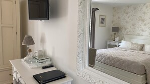 A hotel room with a bed, a desk with a laptop, a mirror, and a wardrobe. - Abbey Green Farm B&b, Camping & Touring Park (Whitchurch)
