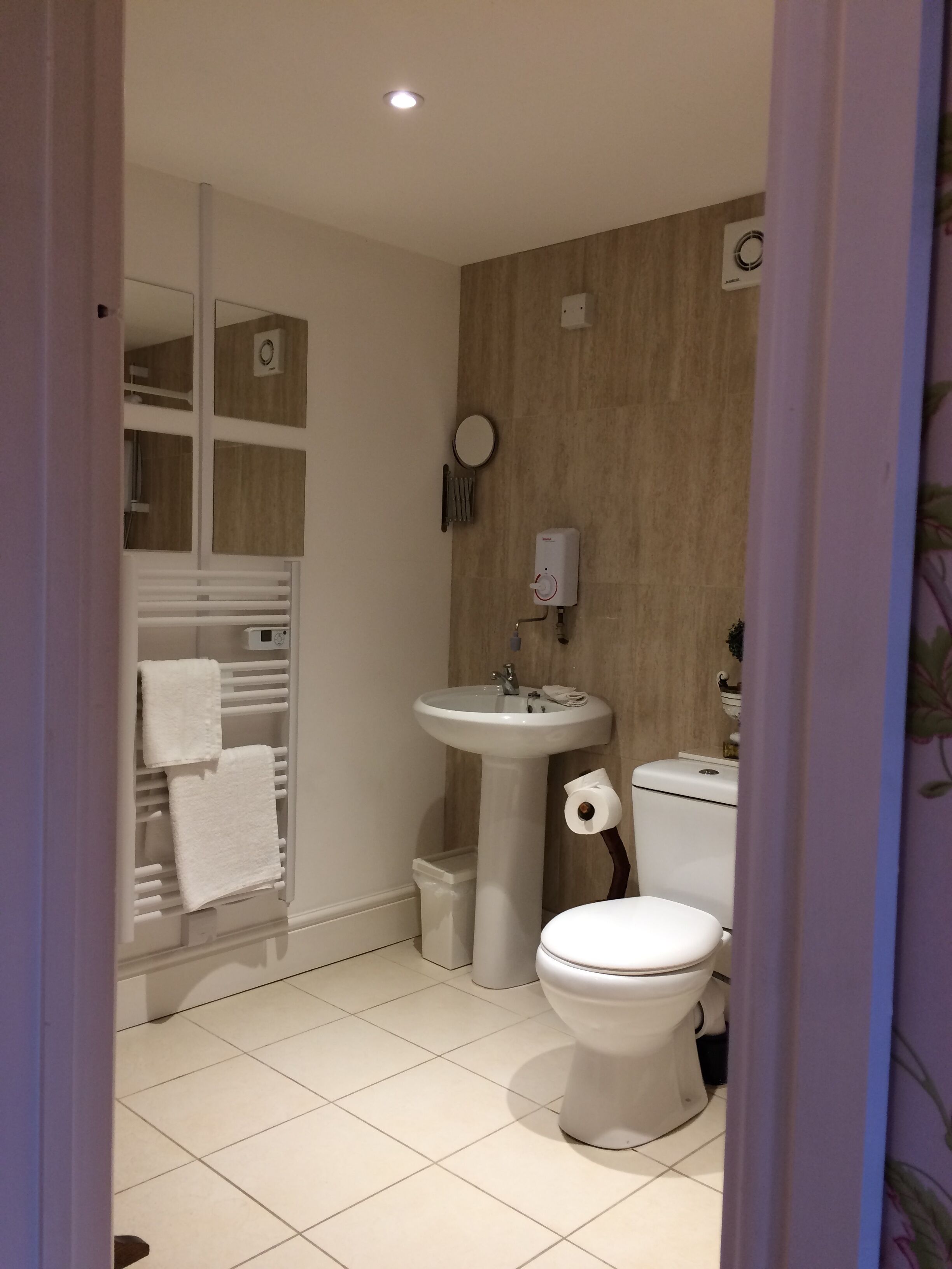 Ein Badezimmer mit Toilette, Waschbecken und Handtuchhalter.