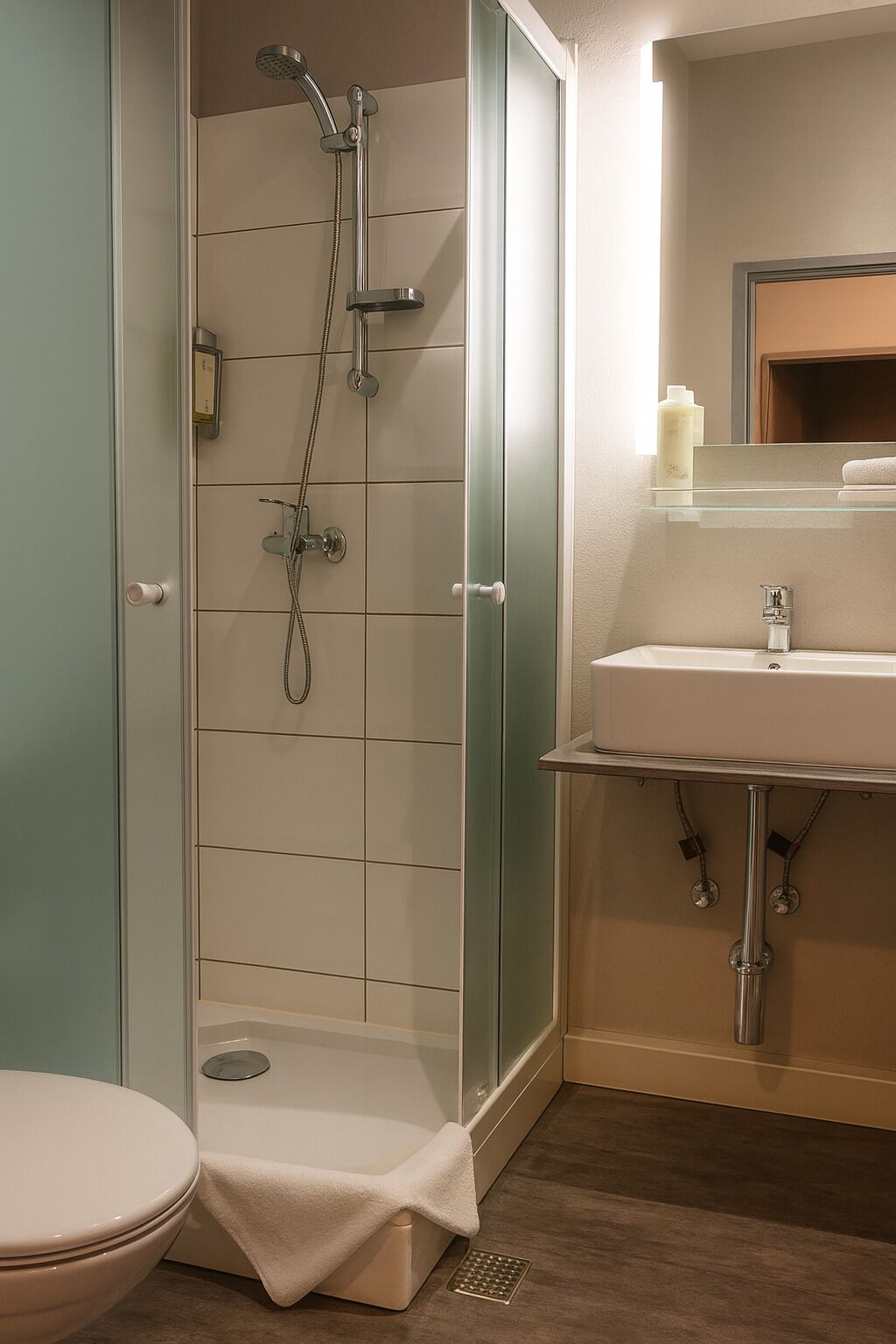 A modern bathroom with a glass-enclosed shower, a white sink, and a toilet.