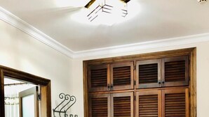 Une pièce avec une armoire en bois, une porte et un crochet fixé au mur.