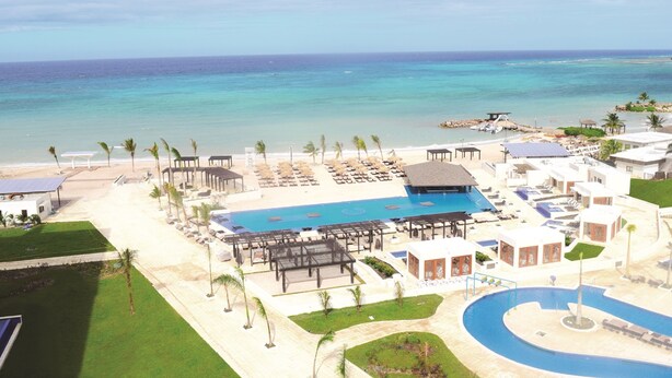 Un complexe hôtelier doté d’une grande piscine, d’une plage et offrant une vue sur l’océan.