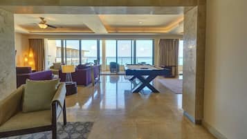 Un salón amplio con mesa de billar, asientos cómodos y vista al mar.