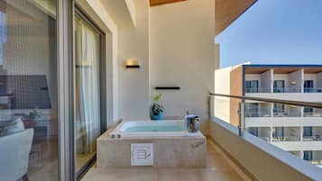 Ein modernes Badezimmer mit einer freistehenden Badewanne, einer Topfpflanze und einer Duschkabine aus Glas.