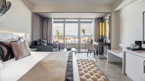 Une chambre d’hôtel moderne dotée d’un grand lit, d’un bureau et d’un balcon offrant une vue sur la ville.