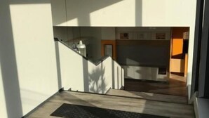 Un interior moderno con una escalera que conduce a una zona de cocina.