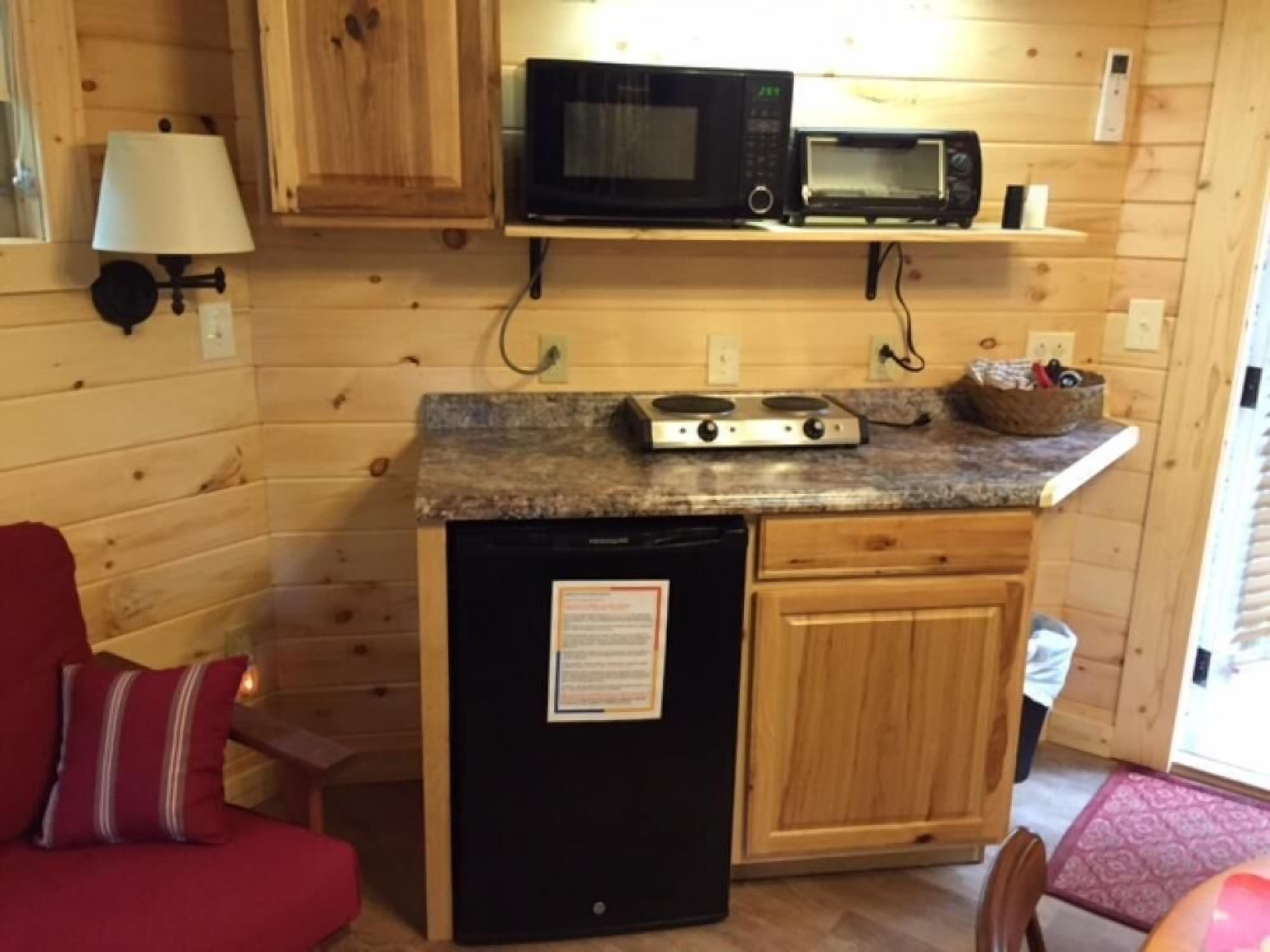 Una cocina compacta equipada con refrigerador, microondas y estufa.
