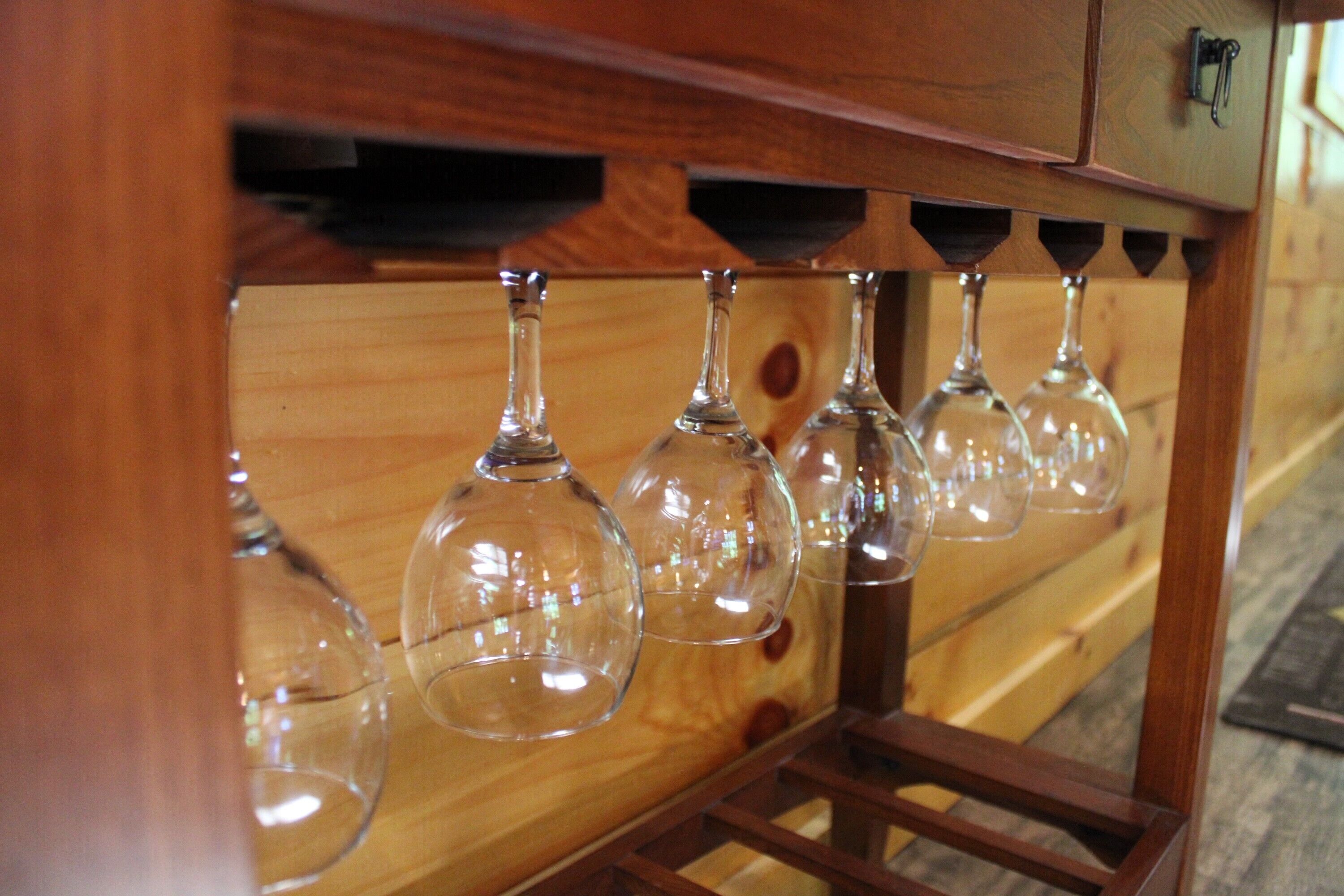 A wooden wine rack with multiple wine glasses.