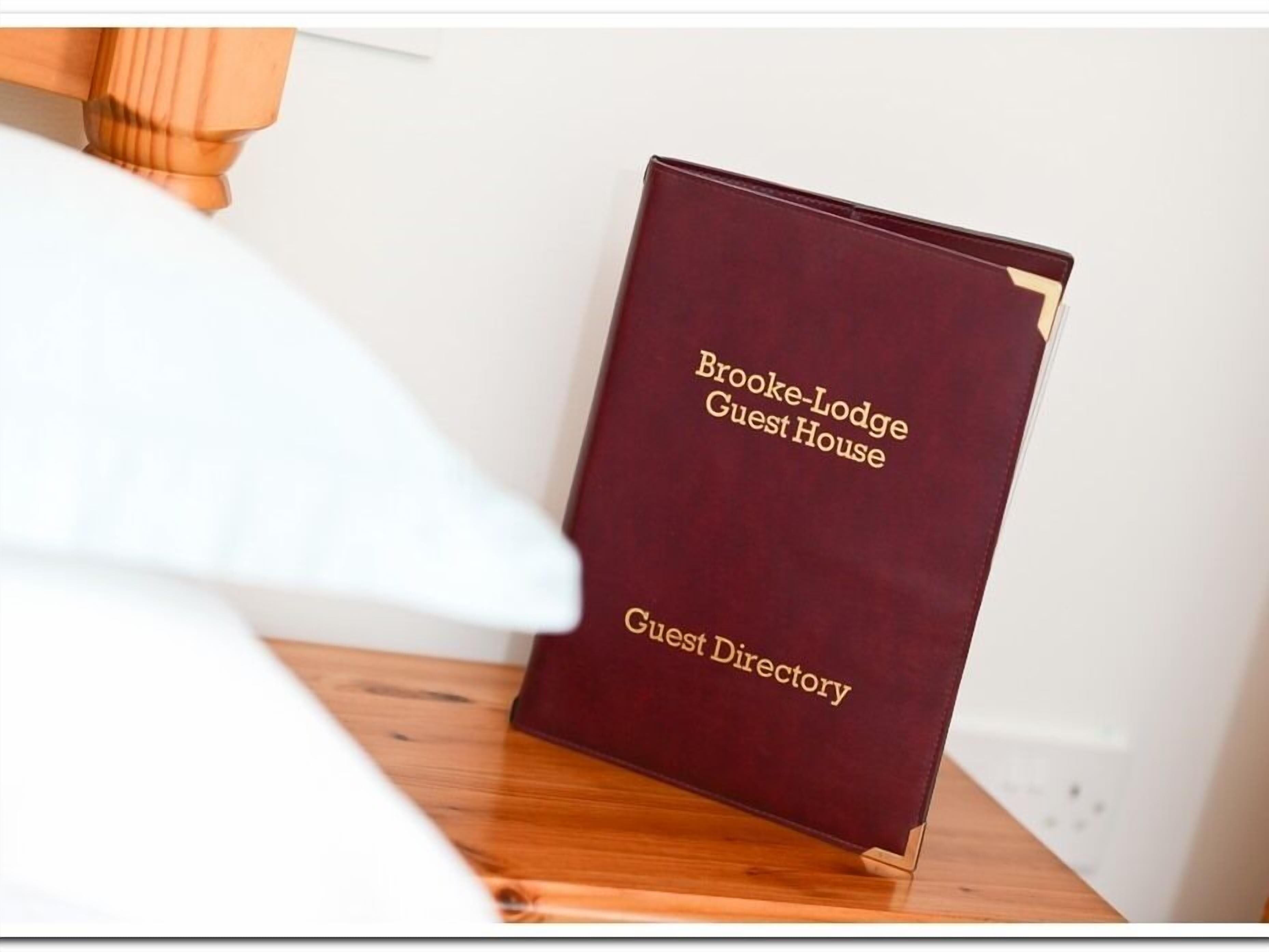 Un directori d'hostes color borgonya per a Brooke-Lodge Guest House.