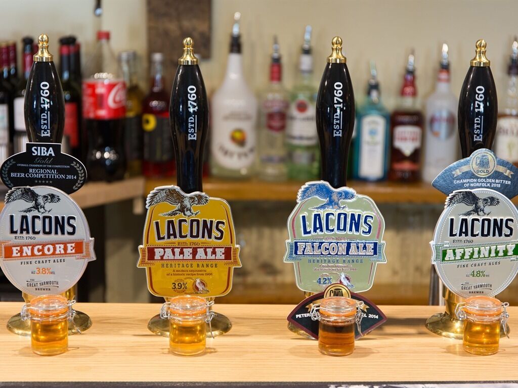 A bar with multiple beer taps, including brands like SIBA, LACONS, and Falcon Ale.