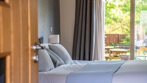 Une chambre à coucher avec un lit, une table de chevet et une fenêtre avec des rideaux.