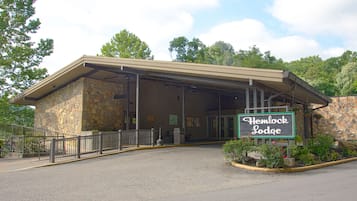 A stone building with a covered entrance and a sign reading "Hemlock Lodge."