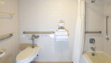 A bathroom with a toilet, a bathtub, and a shower.