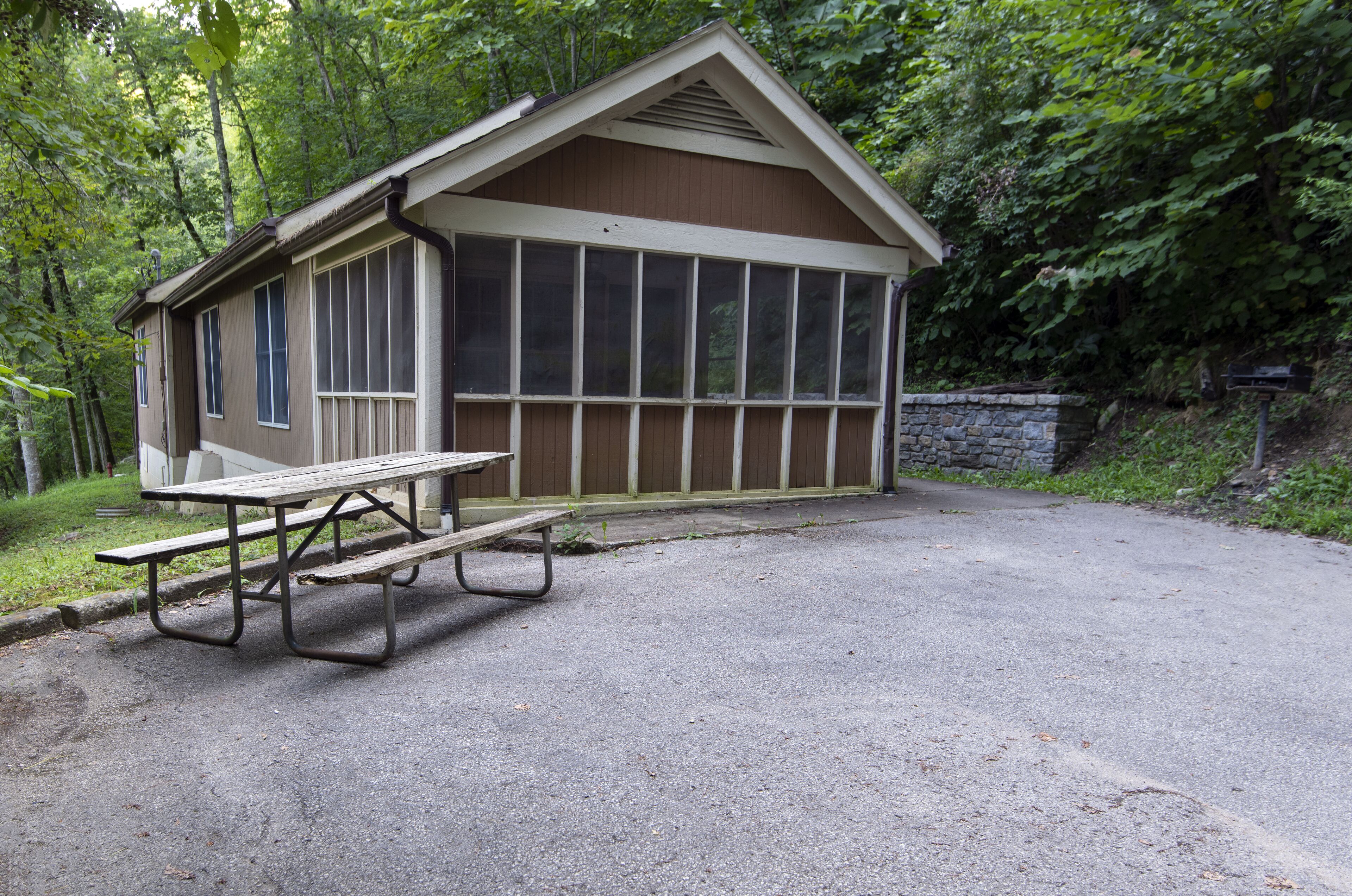 A small wooden cabin with a picnic table in front.