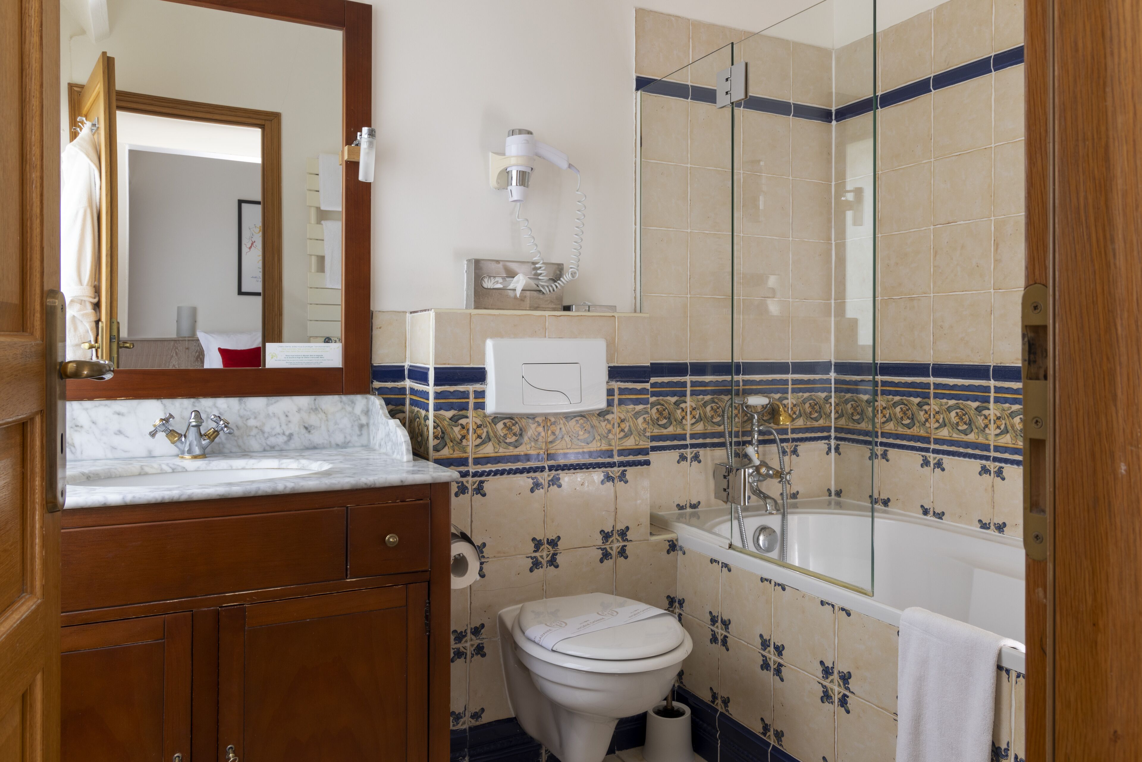 A bathroom with a marble sink, a toilet, a bathtub, and a shower.