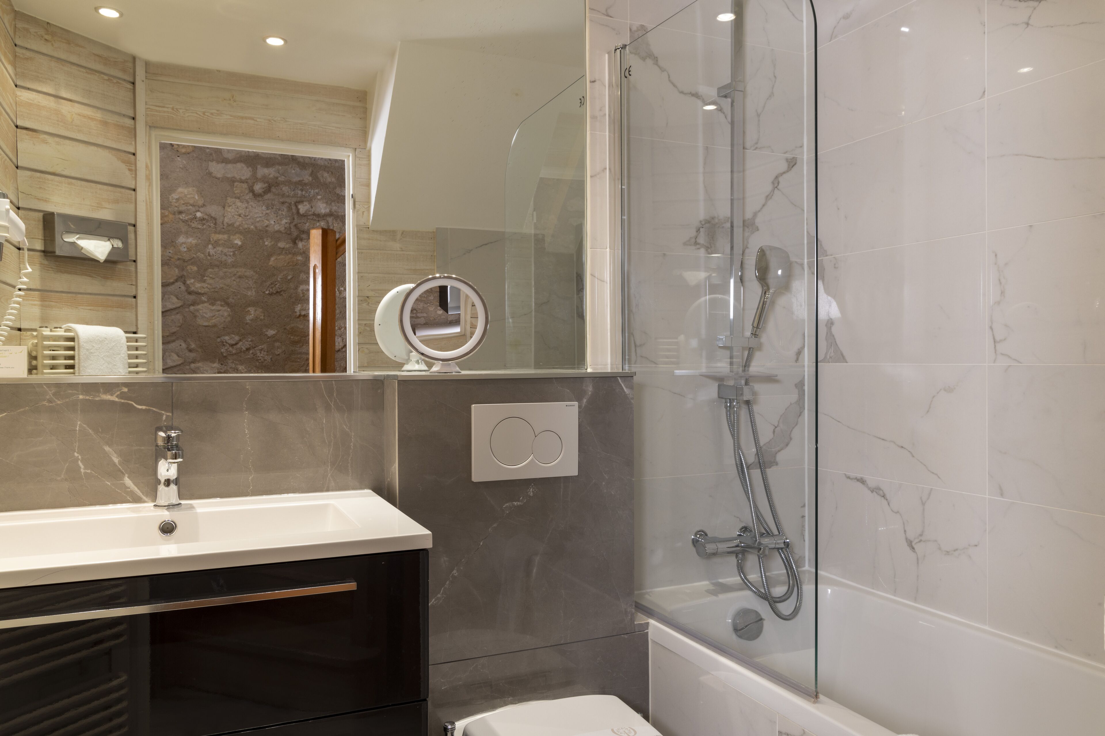 Une salle de bain moderne avec une douche à parois de verre, un meuble-lavabo avec un miroir et des toilettes.